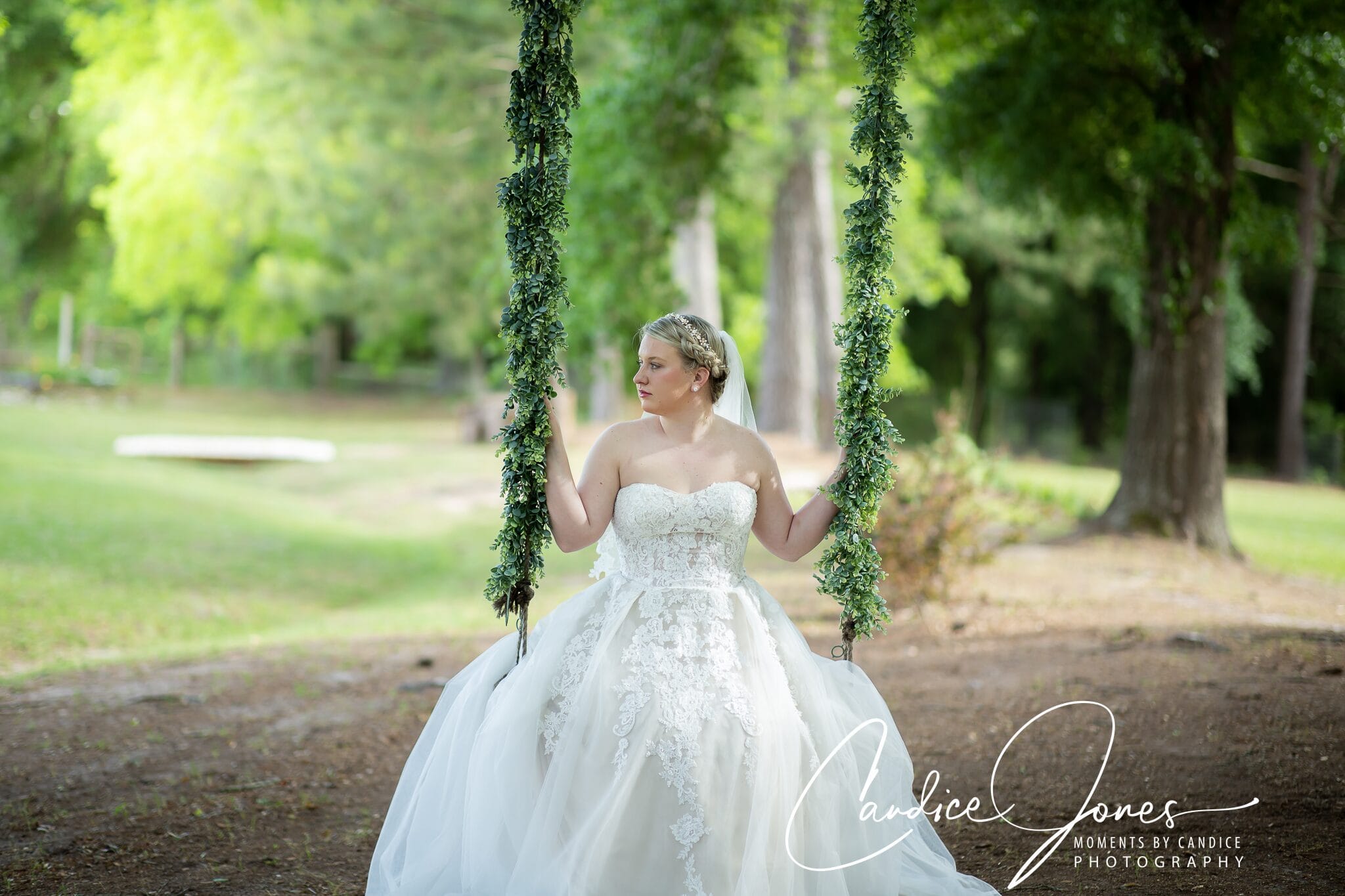 Bride on a garland-wrapped swing in a summer garden